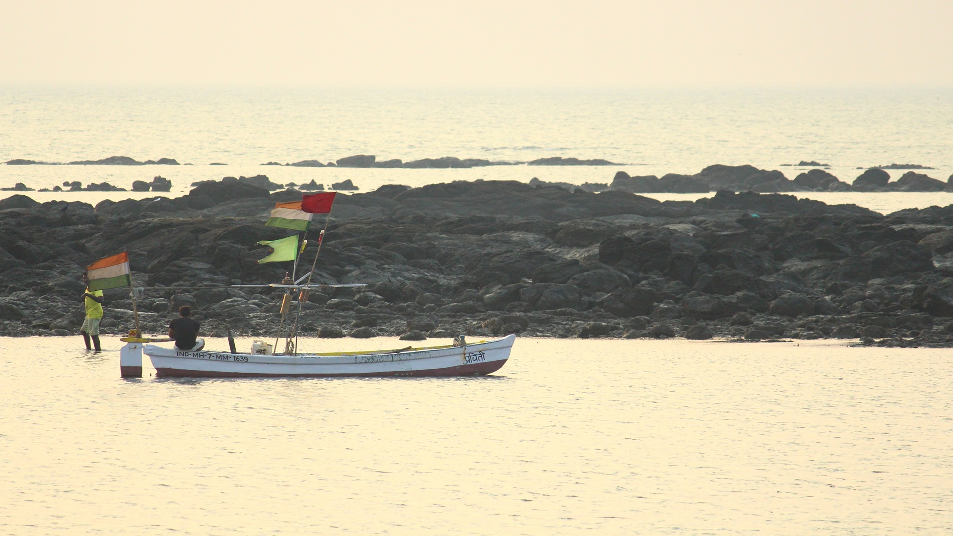 two fishermen waiting for the high tide so that they can take their boat to the sea for fishing